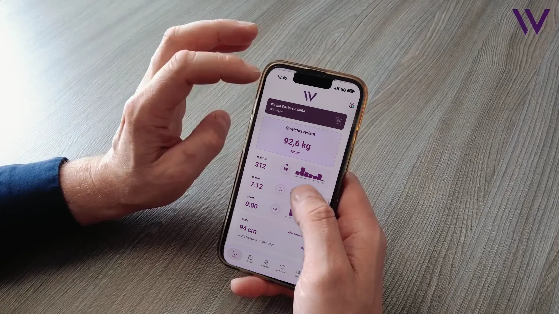Una mano tiene uno smartphone con la Weight Doctors® App aperta