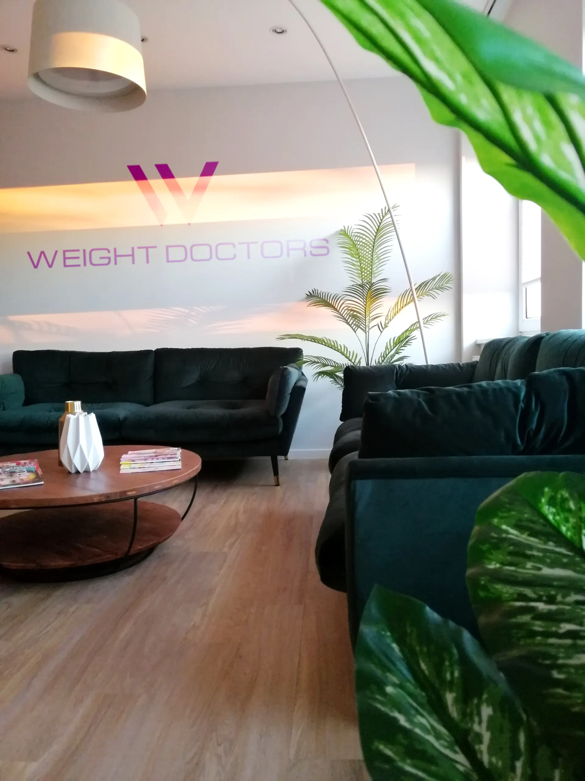 A Weight Doctors® lounge zöld kanapékkal és a falon lévő felirattal