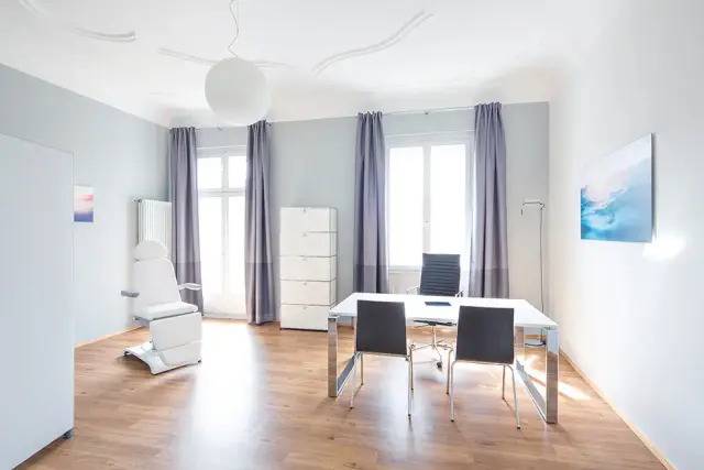 Helle Beratigszimmer mit Schriibtisch und Behandligslieg bi Weight Doctors® in Frankfurt am Main