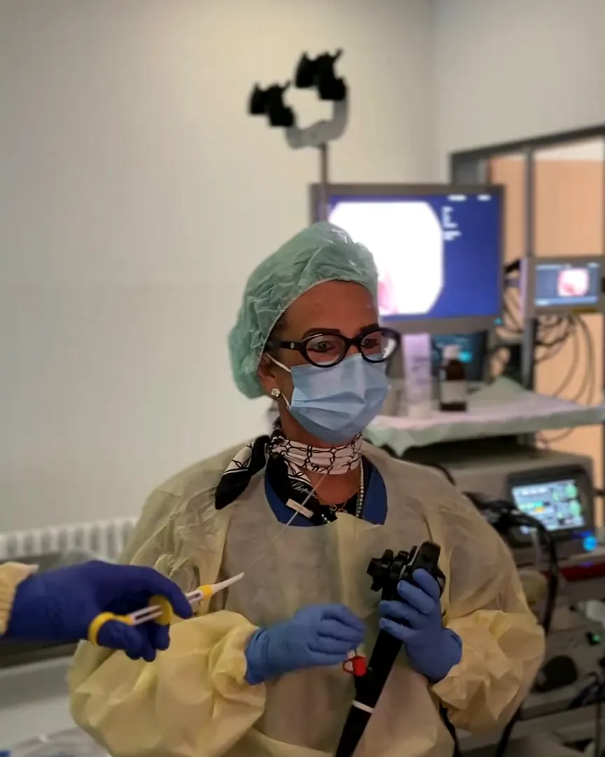 Dottoressa con l’endoscopio davanti ai monitor nella sala di esame