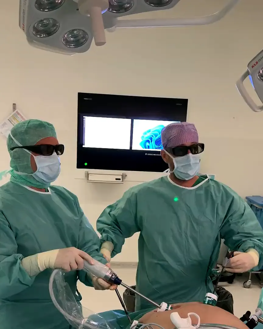 Zwei Chirurge mit 3D-Brille operiered i Schlüssellochtechnik, dihinder de Monitor