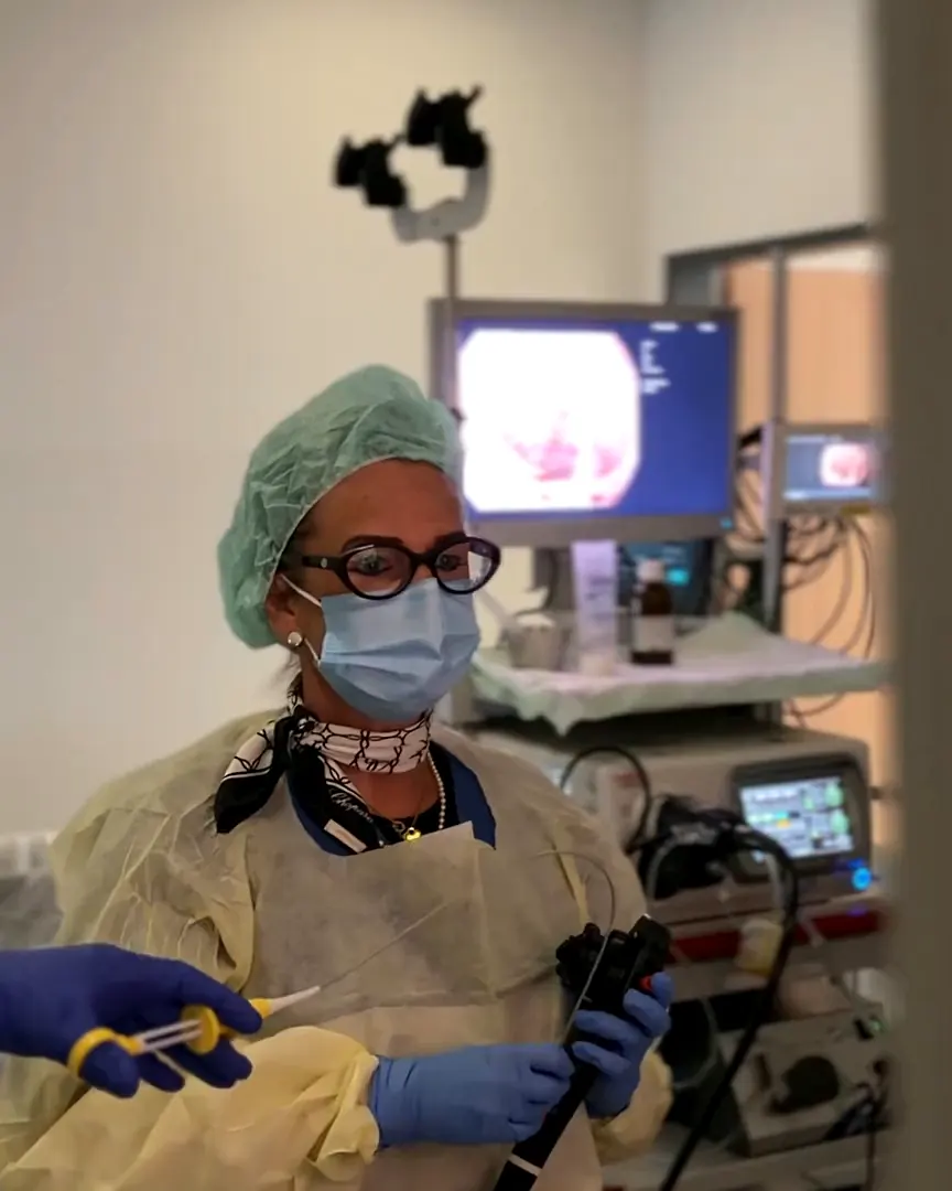 Dottoressa con l’endoscopio davanti ai monitor nella sala di esame
